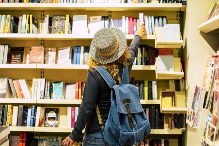 woman reaching for a book in a public library